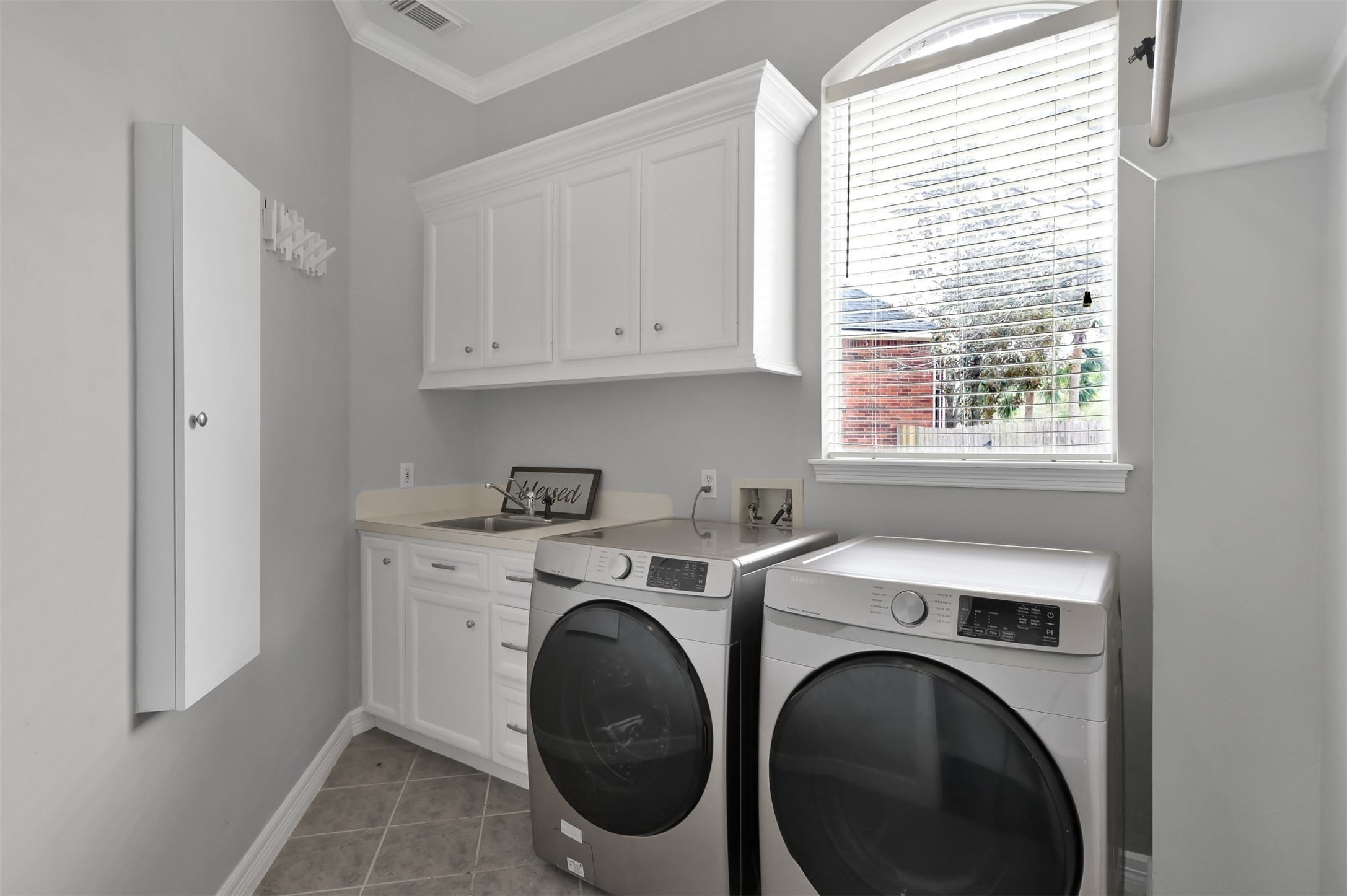9706 Chipstead Court Spring, TX 77379 - Photo 22 of 44 Located on the first floor between your kitchen and dining room is your laundry room complete with a sink, place to fold clothes, storage and ample hanging room too.