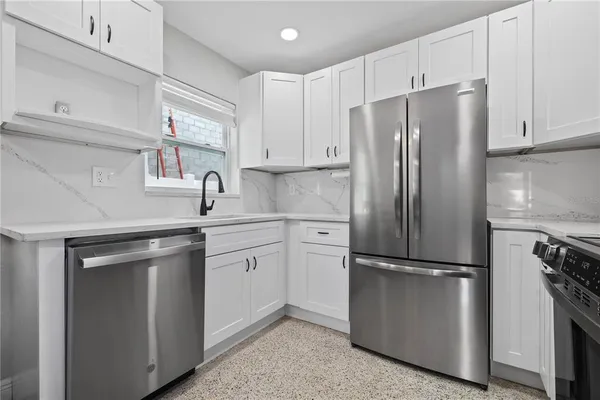 a kitchen with stainless steel appliances a refrigerator sink and cabinets