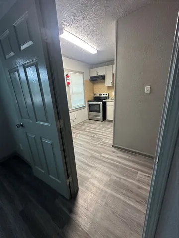 a view of a hallway with wooden floor and staircase