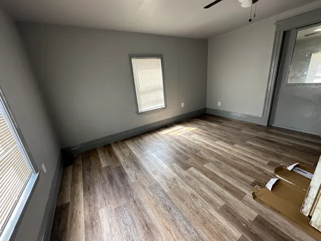 a view of an empty room and wooden floor and a window