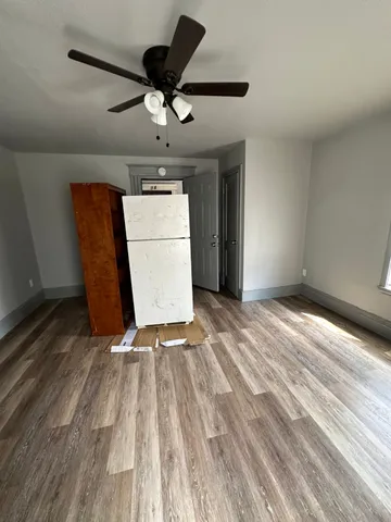 a view of empty room with wooden floor