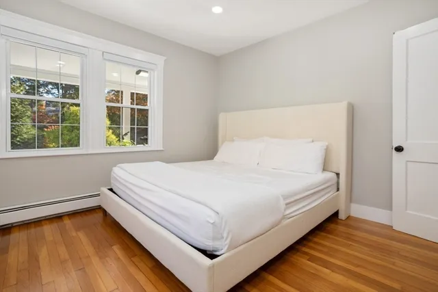 a view of a bedroom with cabinet mirror and window