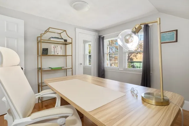 a view of an empty room with wooden floor and windows