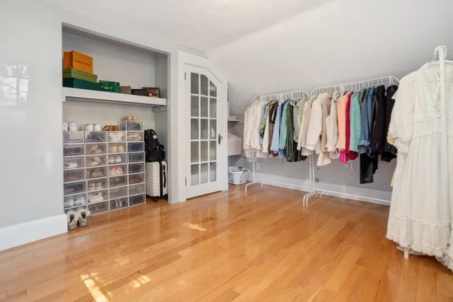 a view of a kitchen with an empty room and wooden floor