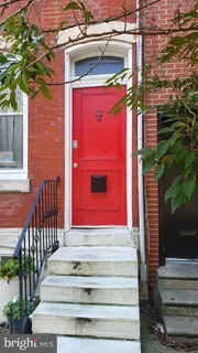 a view of a house with a door and wooden bench
