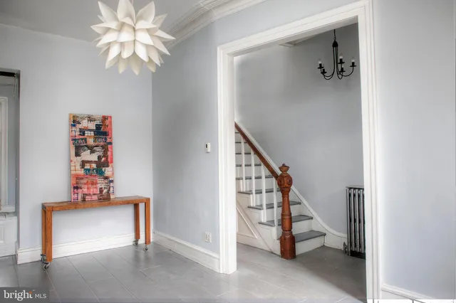 a view of staircase with lots of frames on wall and a window