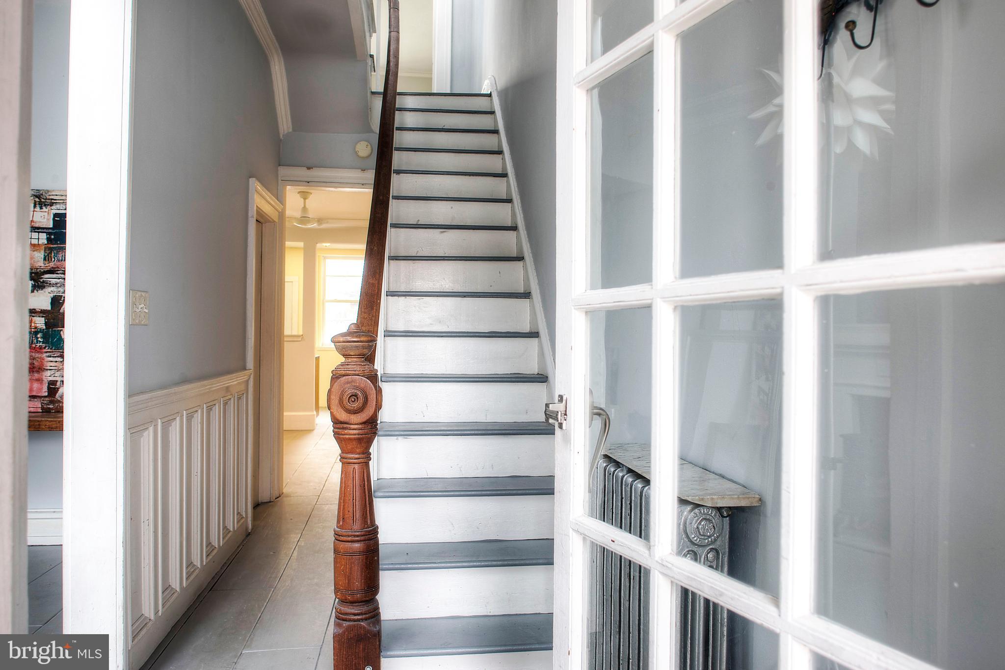 1228 Catharine Street Philadelphia, PA 19147 - Photo 7 of 32 a view of staircase with lots of frames on wall and a window