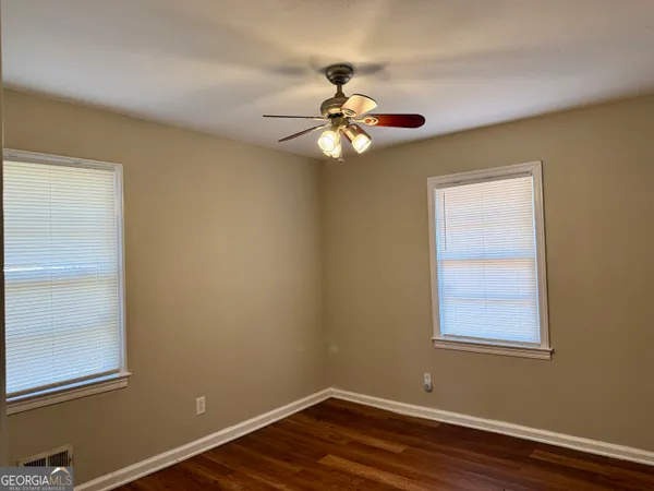a view of a room that has a window and wooden floor