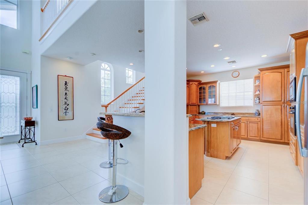 7352 Gulf Way Hudson, FL 34667 - Photo 12 of 69 a kitchen with stainless steel appliances kitchen island granite countertop a refrigerator a sink a stove a dining table and chairs