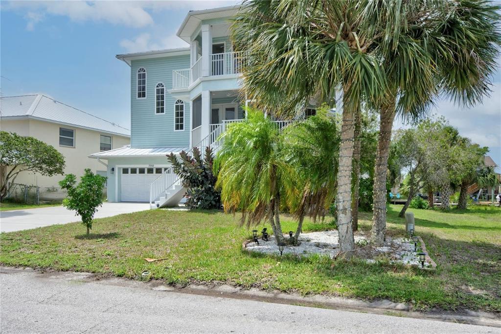7352 Gulf Way Hudson, FL 34667 - Photo 2 of 69 a view of a house with a yard and palm trees