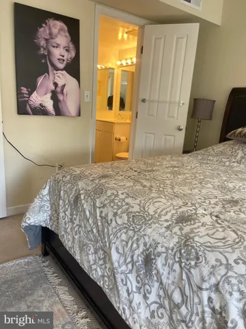 a bedroom with a bed and a painting on the wall