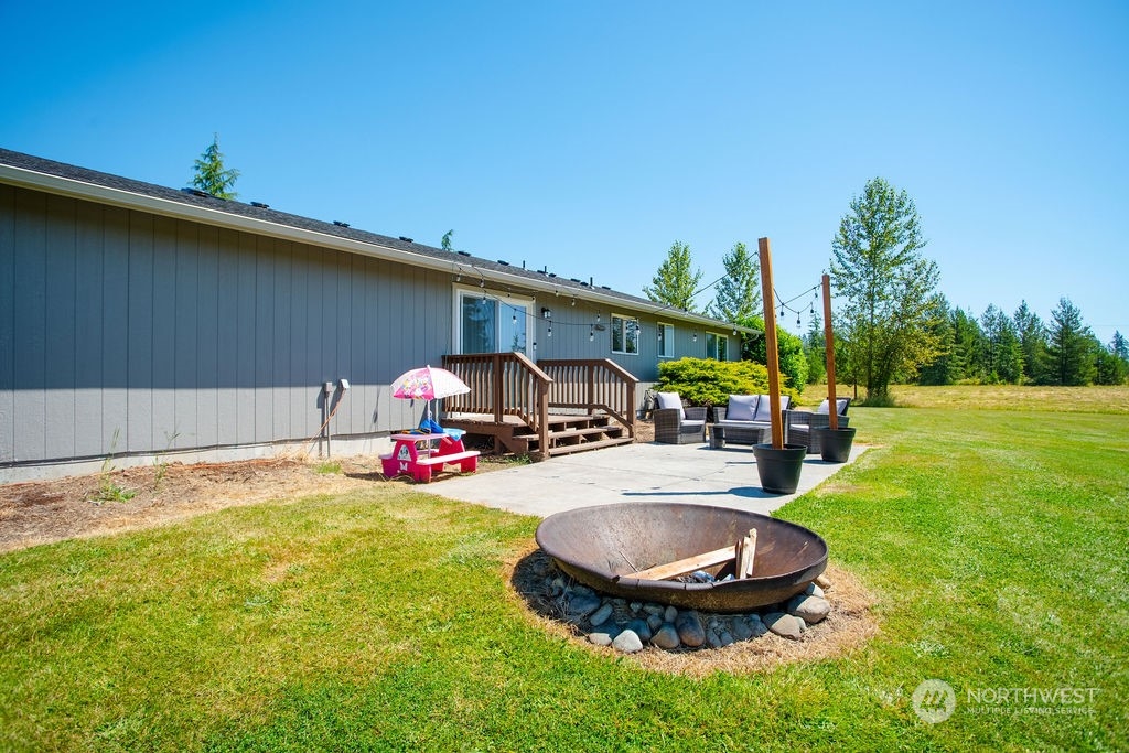 250 Classe Road Toledo, WA 98591 - Photo 16 of 25 a view of a backyard with table and chairs under an umbrella