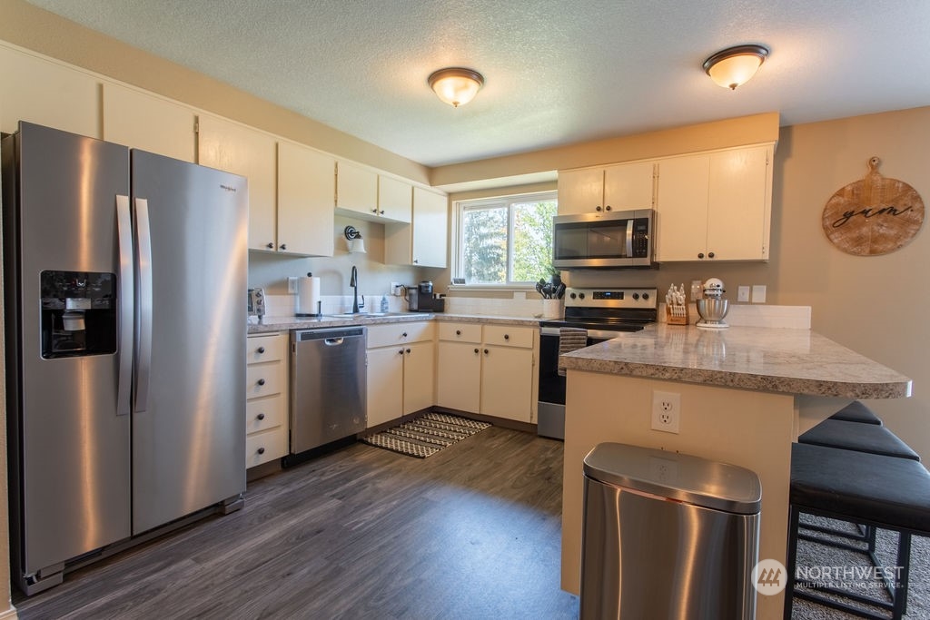 250 Classe Road Toledo, WA 98591 - Photo 7 of 25 a kitchen with stainless steel appliances granite countertop a stove top oven a refrigerator a sink and dishwasher with wooden floor
