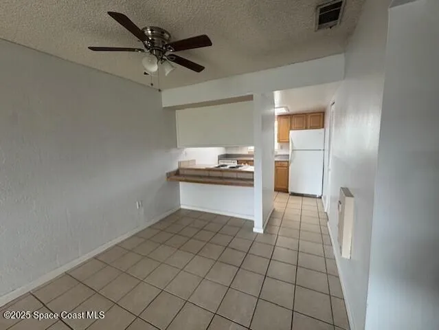 a view of an empty room and kitchen view