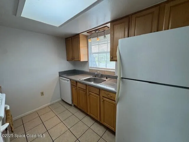 a view of a kitchen with refrigerator and window