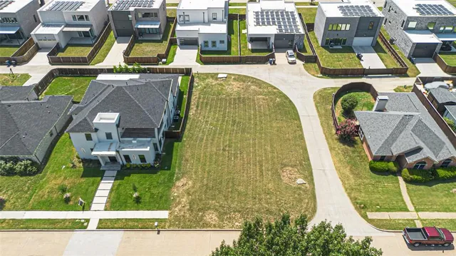 an aerial view of a swimming pool with a yard and plants