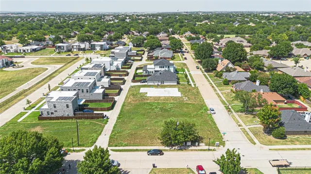 an aerial view of residential houses with outdoor space and swimming pool