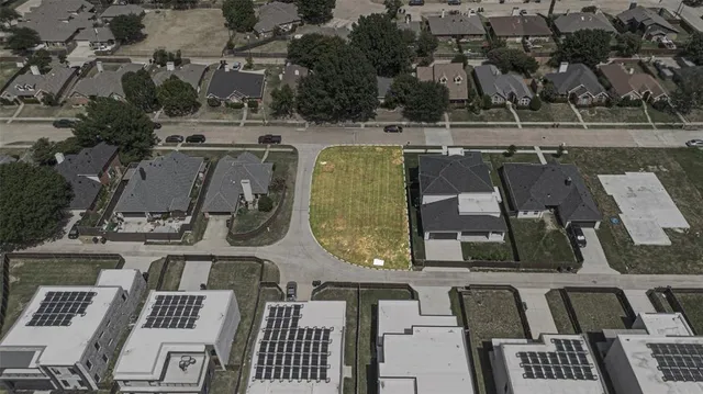an aerial view of a residential houses with outdoor space and parking