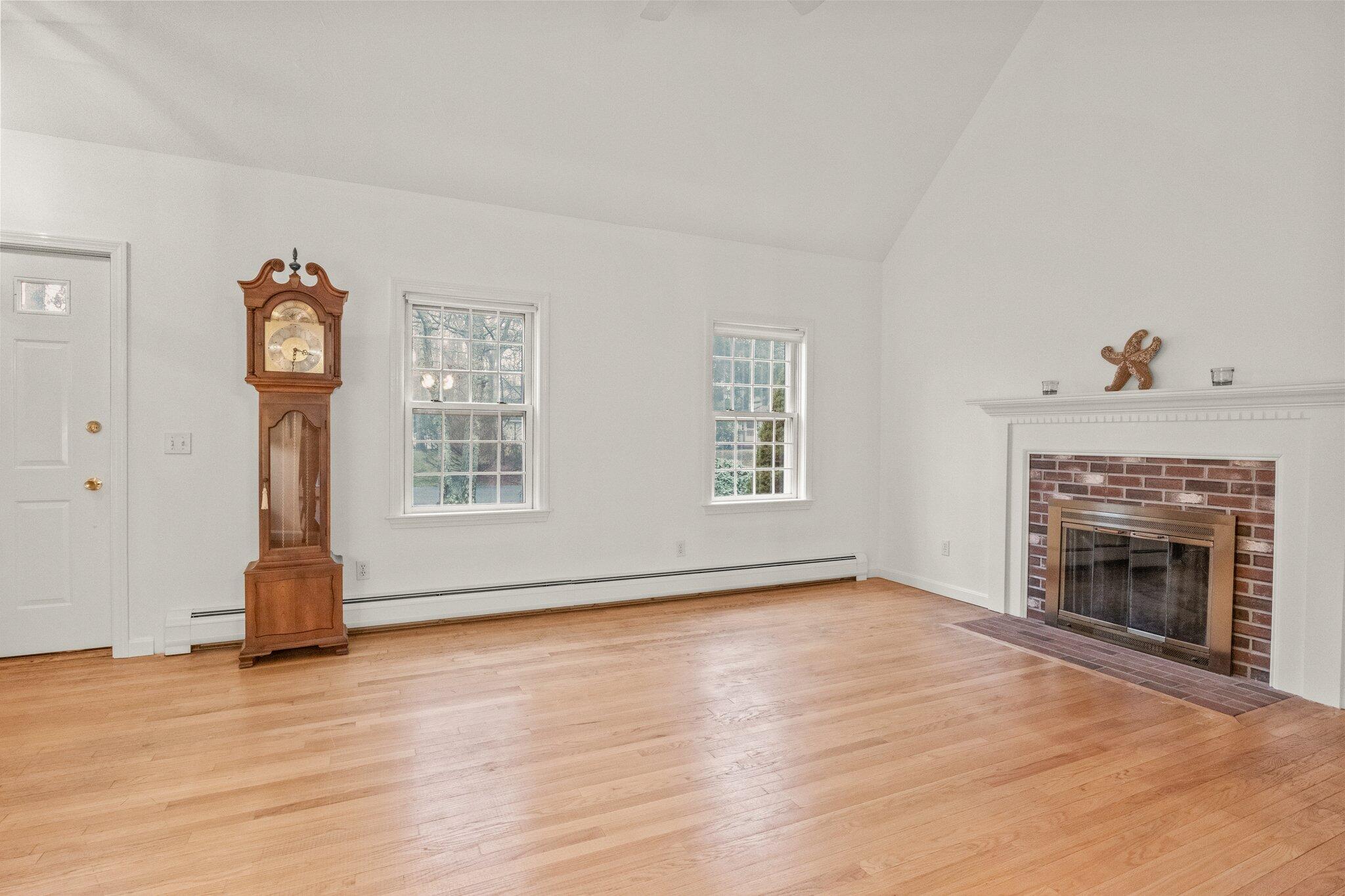52 Goose Point Road Centerville, MA 02601 - Photo 12 of 71 wooden floor fireplace and windows in an empty room