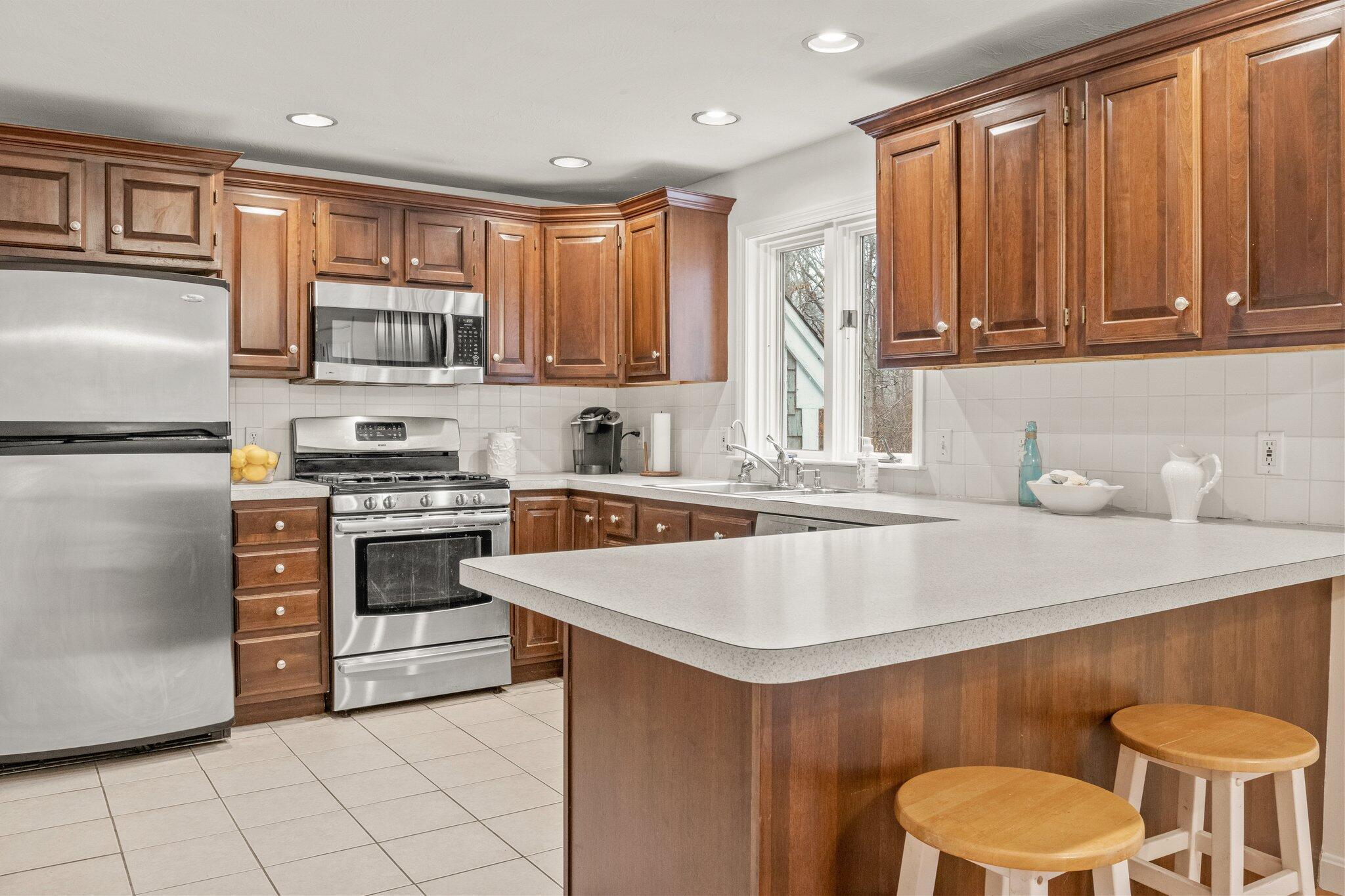 52 Goose Point Road Centerville, MA 02601 - Photo 19 of 71 a kitchen with stainless steel appliances a stove a sink a microwave a refrigerator and cabinets