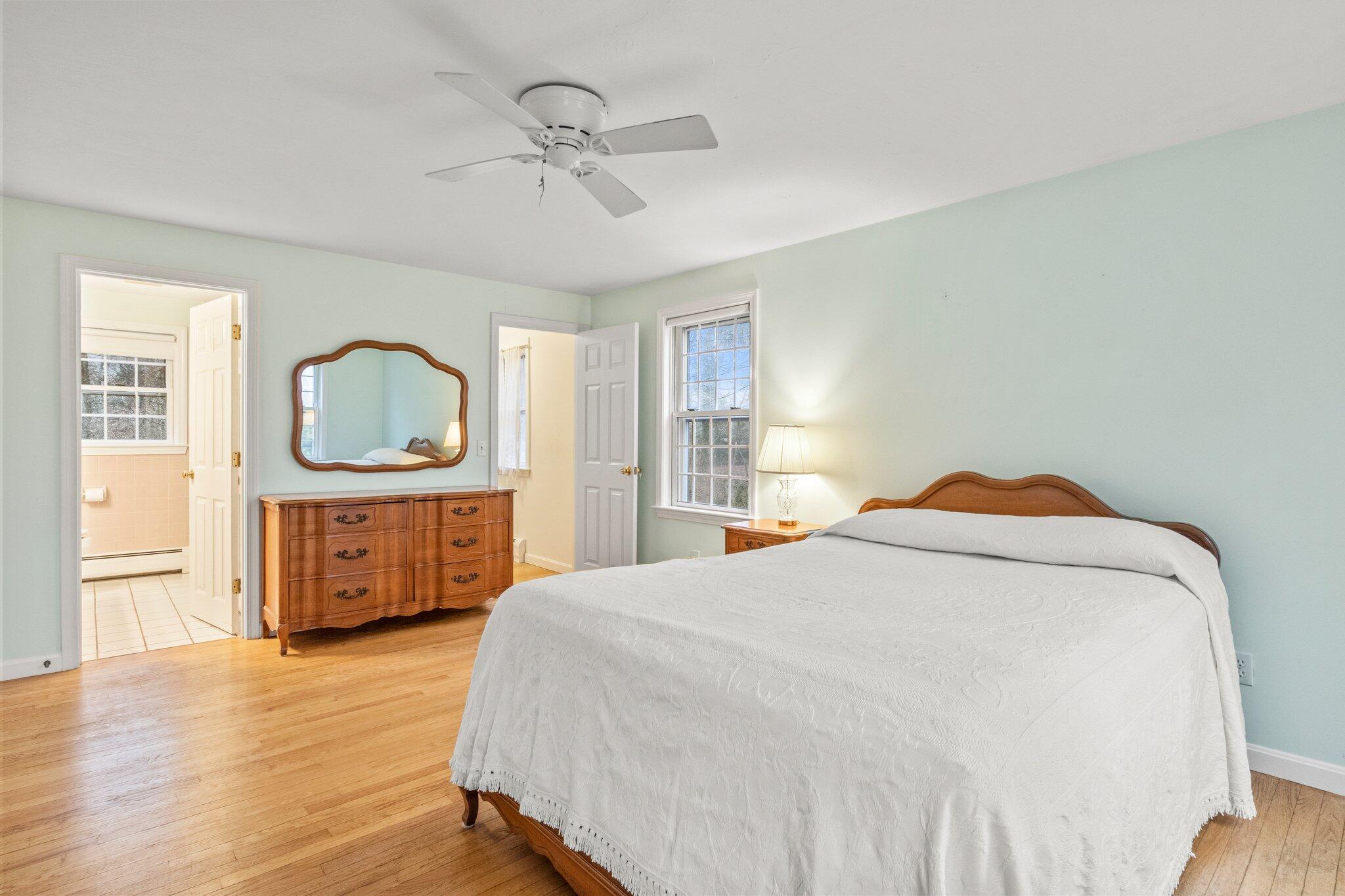 52 Goose Point Road Centerville, MA 02601 - Photo 29 of 71 a bedroom with a bed a mirror on dresser and a wooden floor