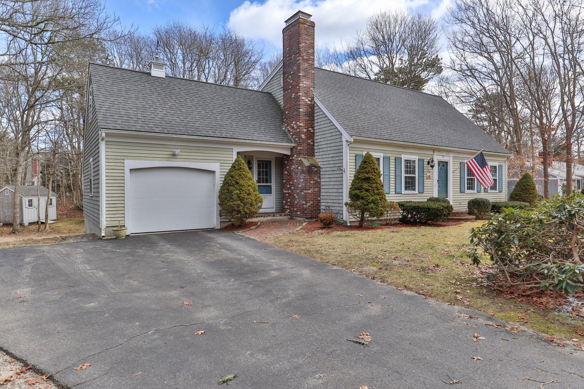 52 Goose Point Road Centerville, MA 02601 - Photo 5 of 71 a front view of a house with a yard and garage
