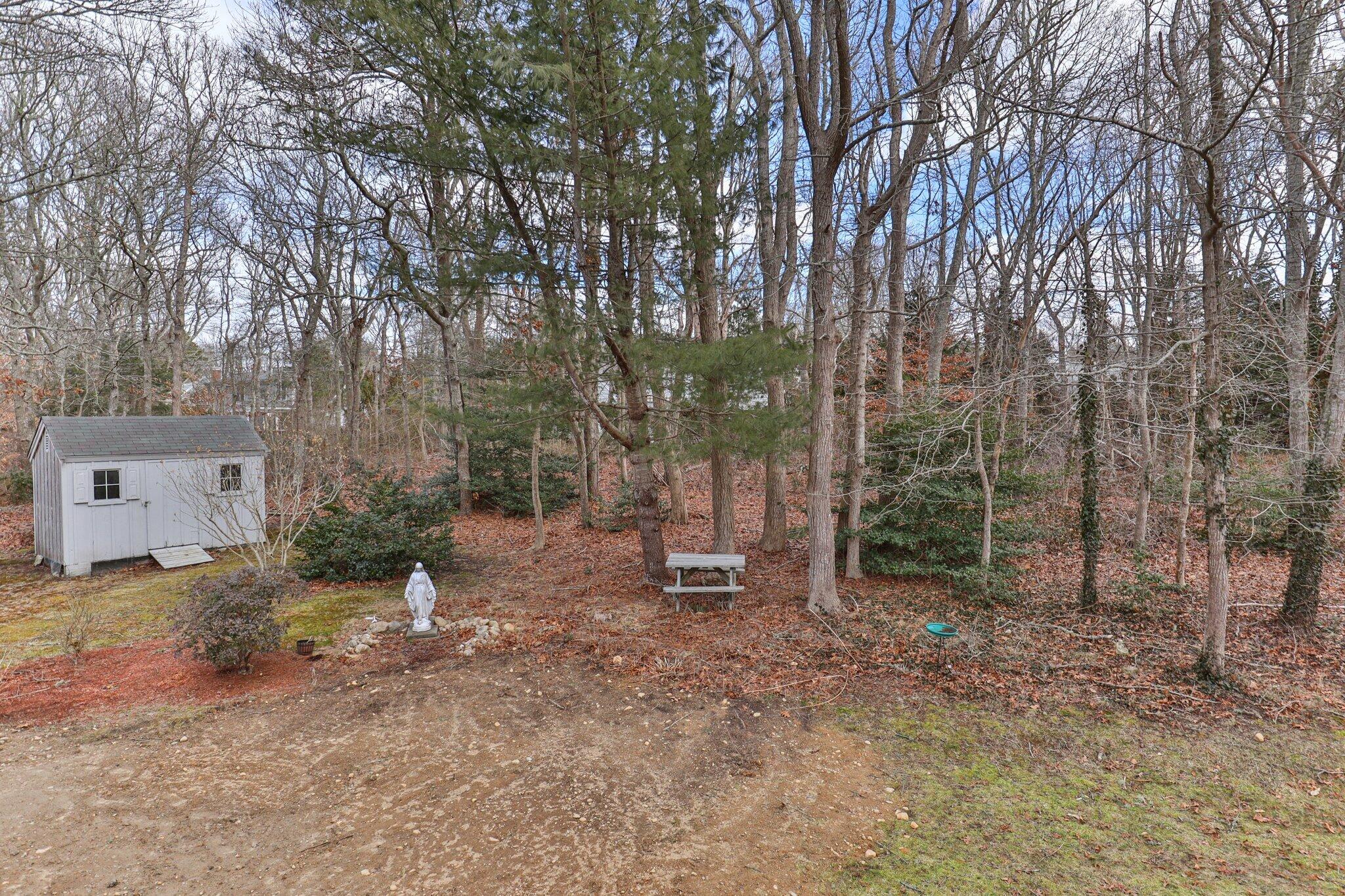 52 Goose Point Road Centerville, MA 02601 - Photo 59 of 71 a backyard of a house with lots of green space