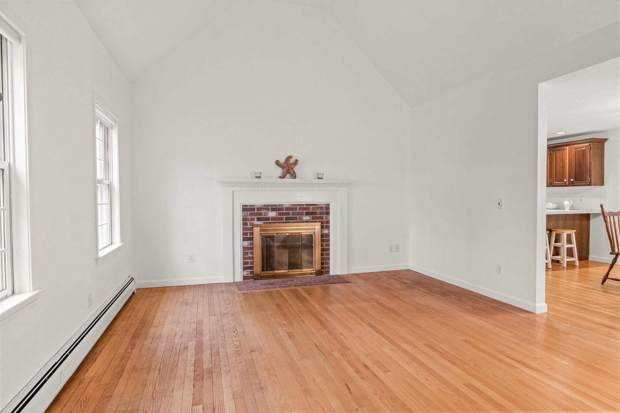 52 Goose Point Road Centerville, MA 02601 - Photo 10 of 71 a view of empty room with wooden floor and fireplace