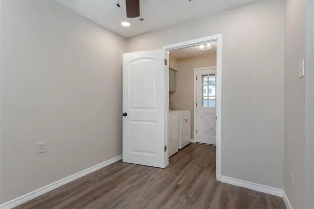 an empty room with wooden floor and mirror