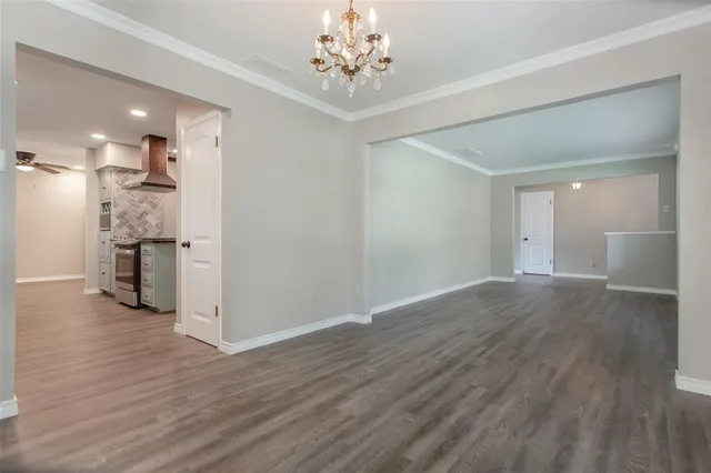 a view of empty room with wooden floor and windows
