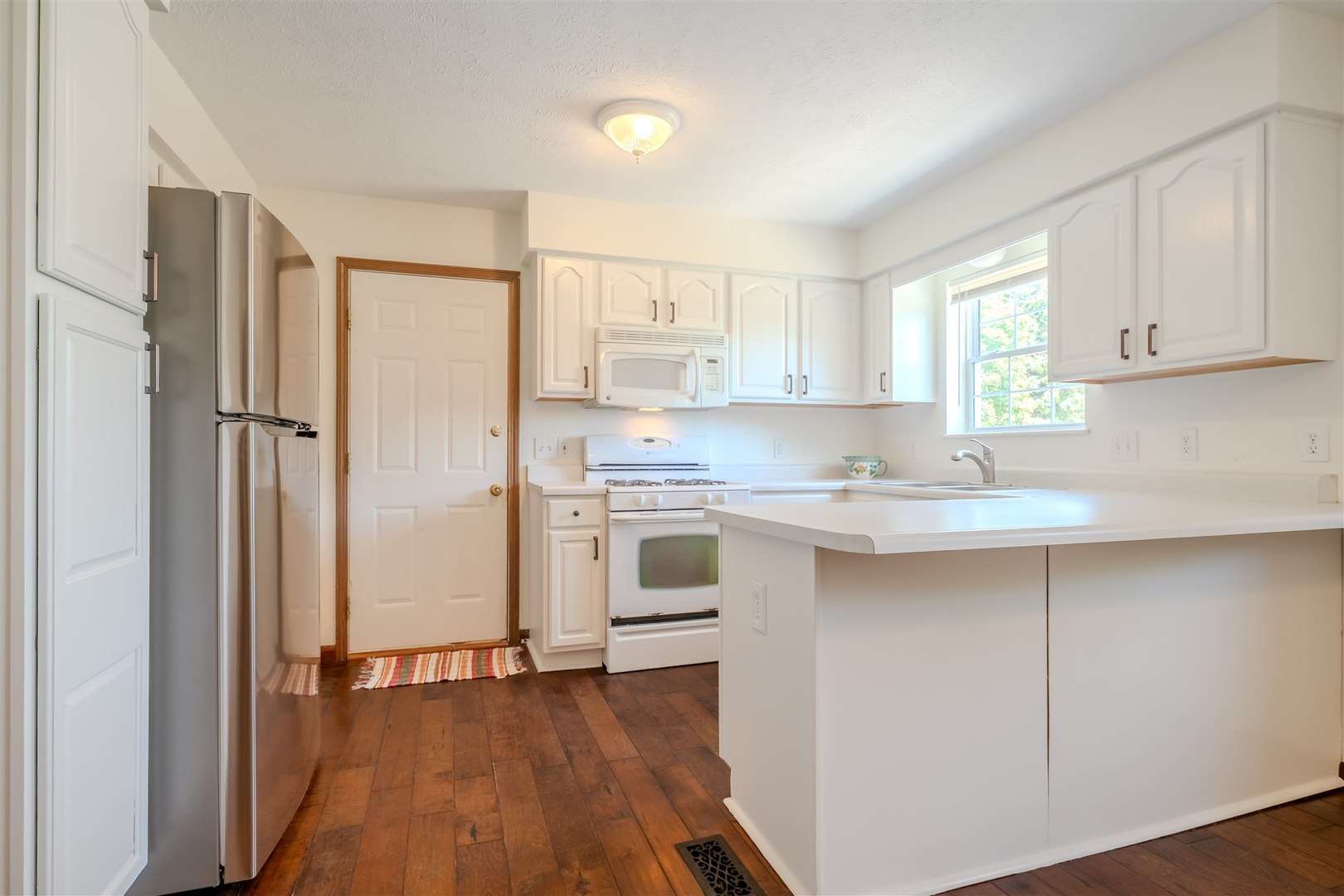 4397 North 3200 East Road Arrowsmith, IL 61722 - Photo 9 of 33 a kitchen with stainless steel appliances granite countertop a refrigerator a sink dishwasher and white cabinets with wooden floor