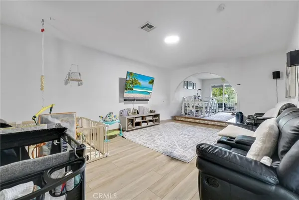 a living room with furniture and a wooden floor