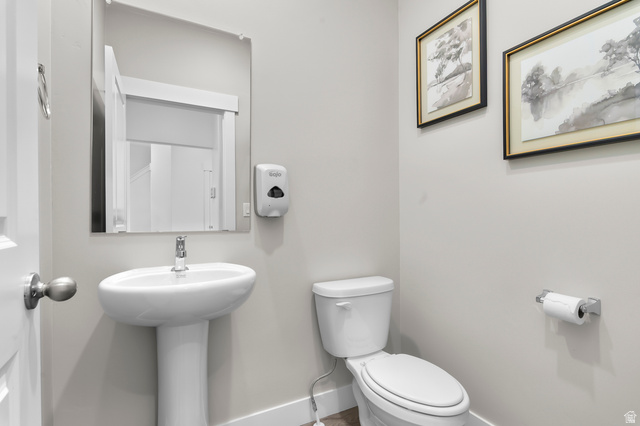 2819 South 710th West, Unit 14 Logan, UT 84321 - Photo 9 of 24 Pedestal sink with chrome faucet, wall-mounted mirror, white toilet, and light gray wall paint