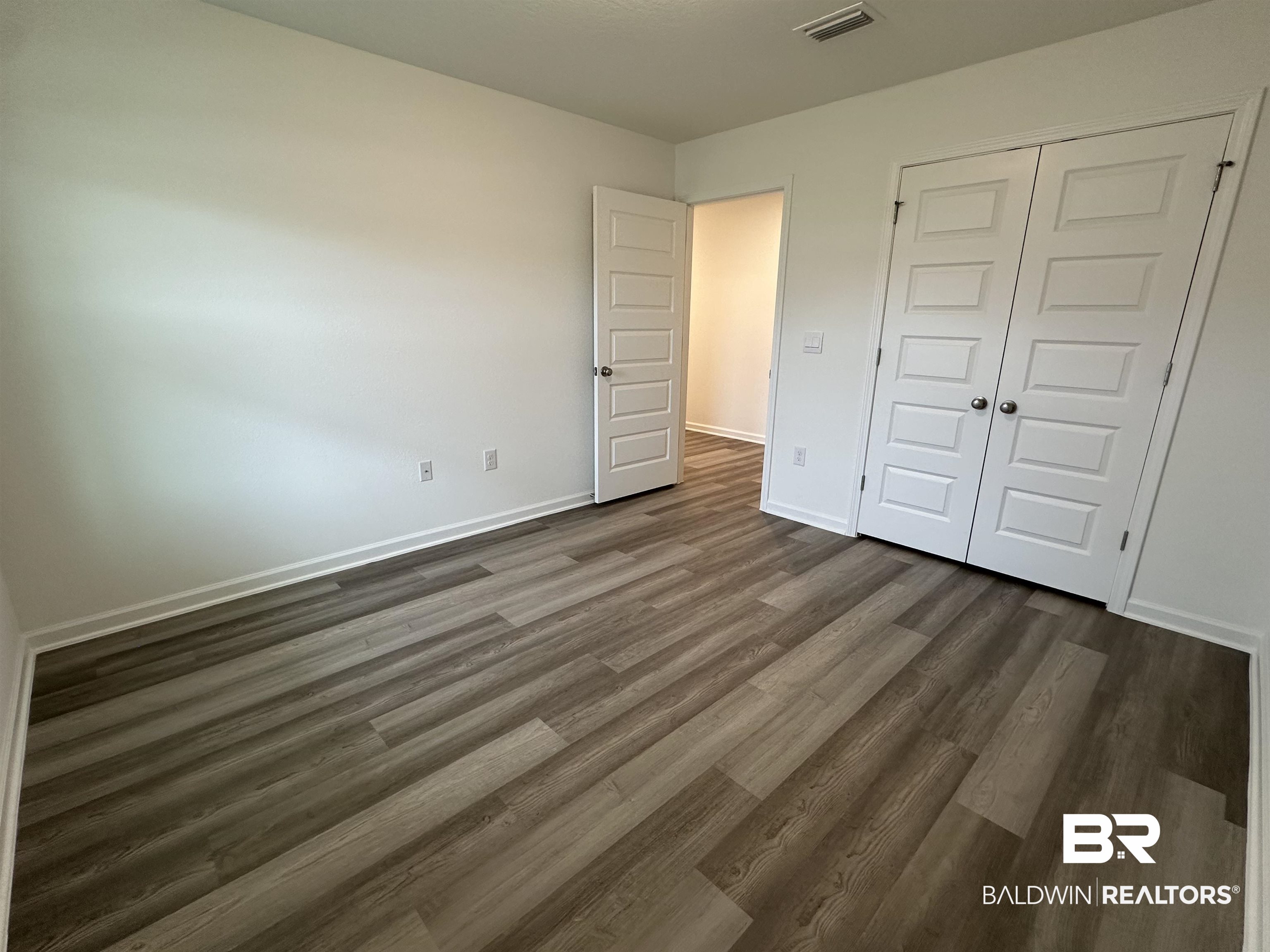 22275 Aleutian Avenue Foley, AL 36535 - Photo 23 of 72 Unfurnished bedroom with dark hardwood / wood-style floors and a closet