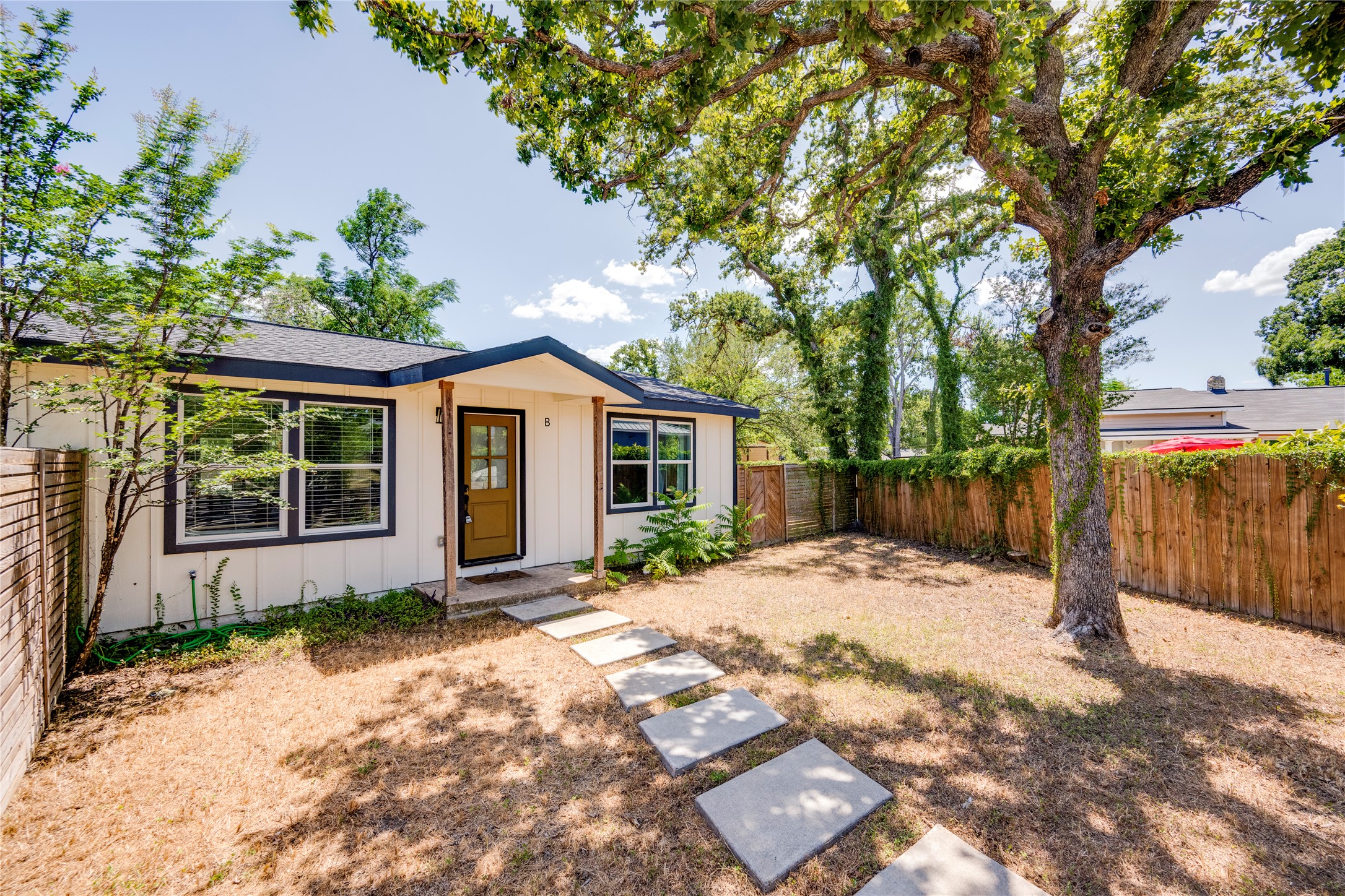 1400 Marcus Place, Unit B Austin, TX 78721 - Photo 3 of 39 A quaint residence featuring a welcoming entry, framed by mature trees, and a spacious, private yard.