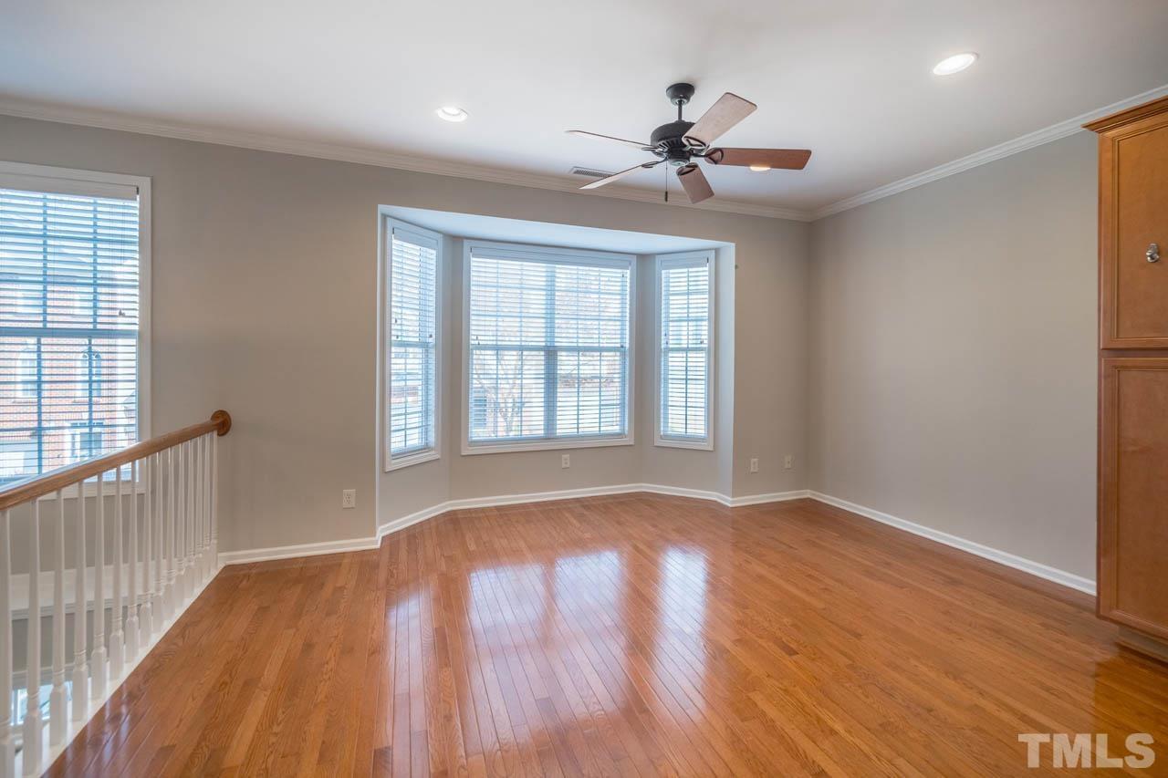 6949 Middleboro Drive Raleigh, NC 27612 - Photo 11 of 35 a view of empty room with wooden floor and fan