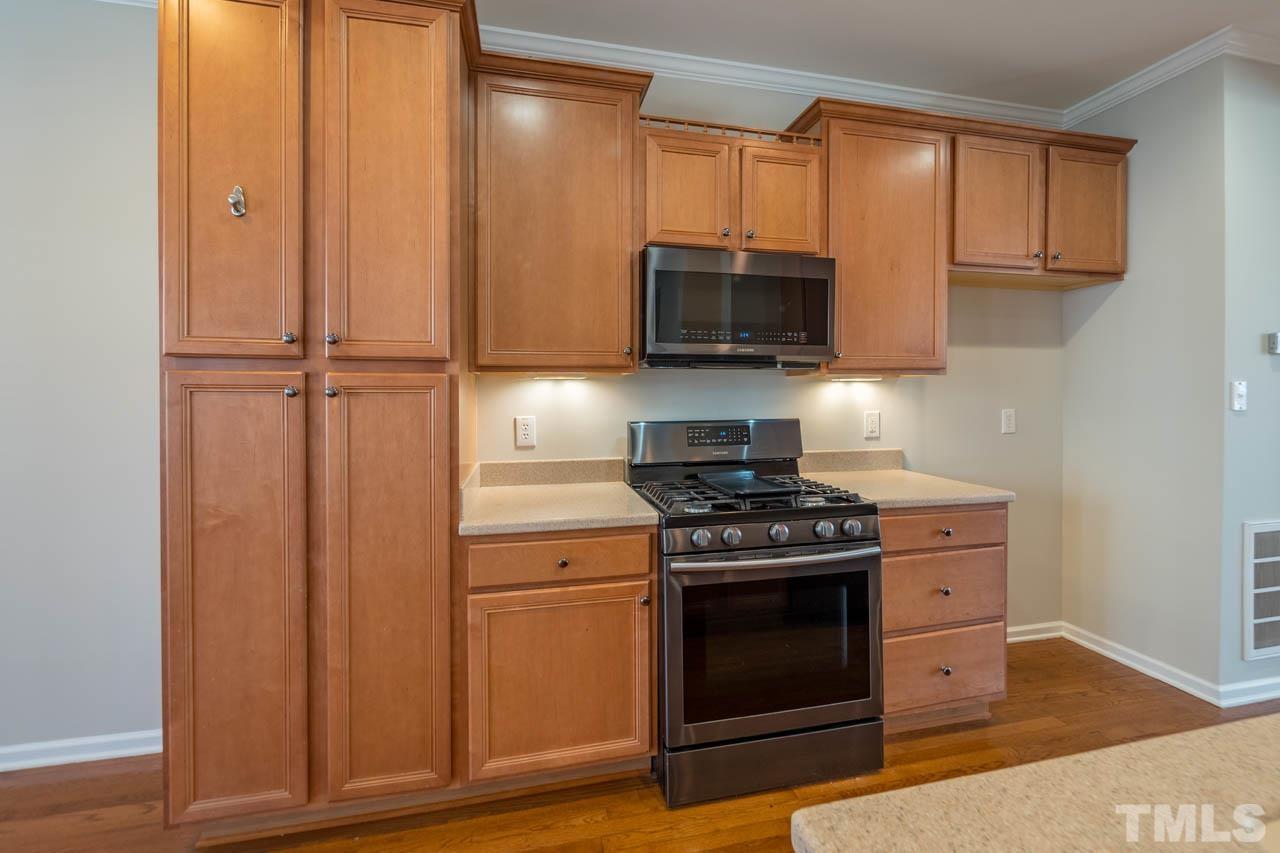 6949 Middleboro Drive Raleigh, NC 27612 - Photo 15 of 35 a kitchen with stainless steel appliances granite countertop a stove a microwave and a refrigerator