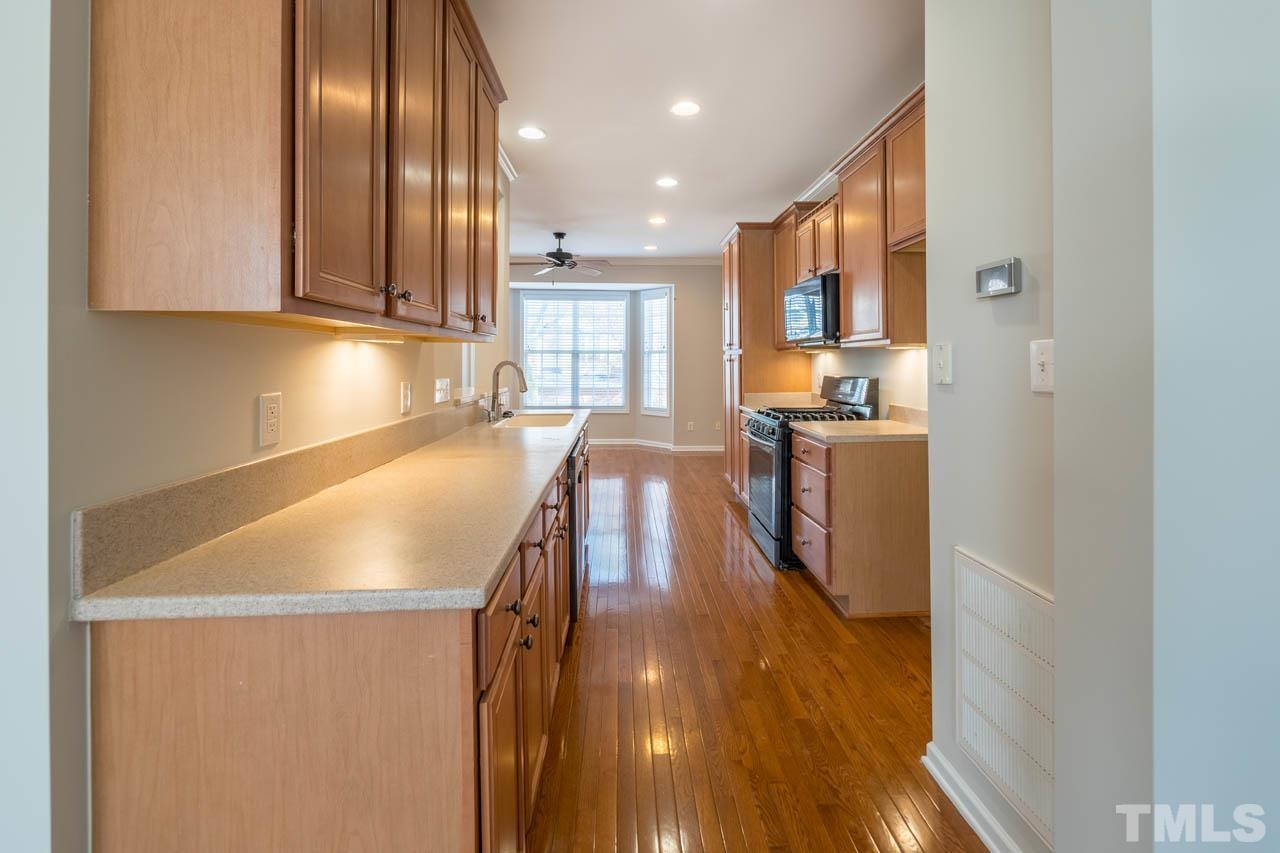 6949 Middleboro Drive Raleigh, NC 27612 - Photo 17 of 35 a kitchen with stainless steel appliances granite countertop a sink a stove and a refrigerator