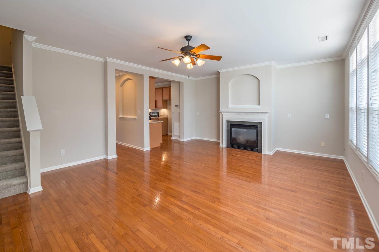 6949 Middleboro Drive Raleigh, NC 27612 - Photo 21 of 35 an empty room with wooden floor fireplace and windows