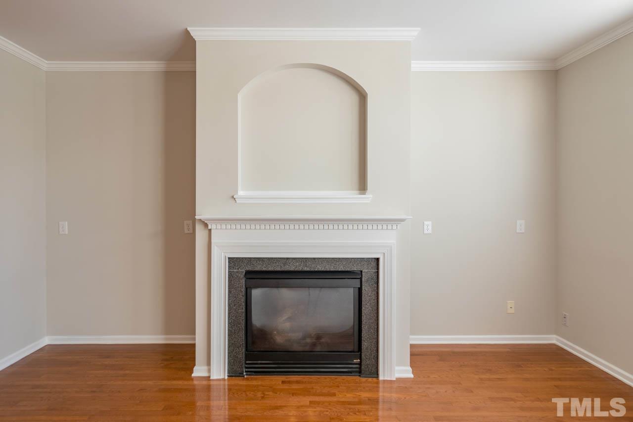 6949 Middleboro Drive Raleigh, NC 27612 - Photo 22 of 35 a living room with a fireplace and wooden floor
