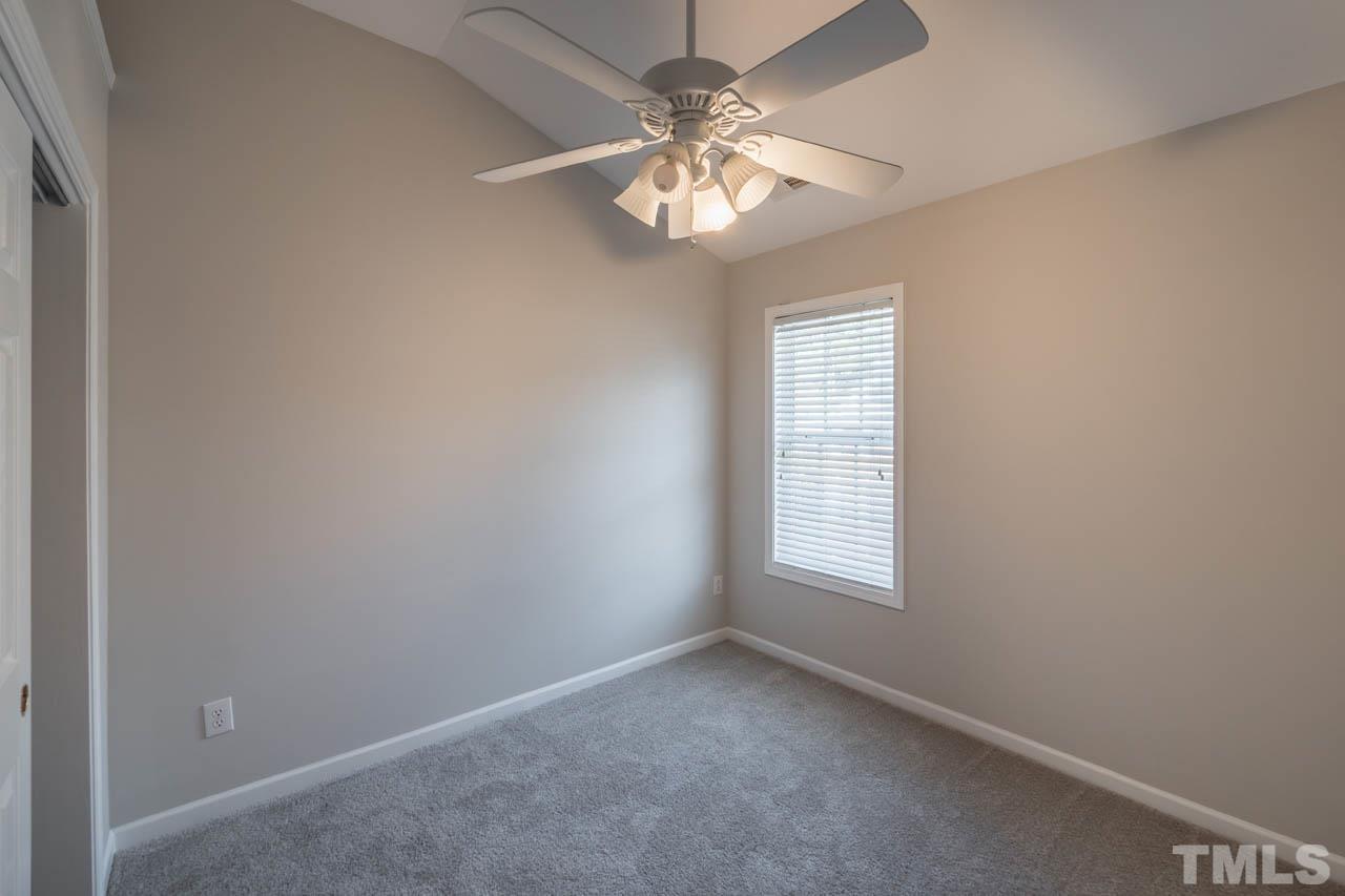 6949 Middleboro Drive Raleigh, NC 27612 - Photo 25 of 35 an empty room with windows and chandelier fan