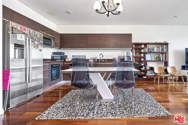 a living room with stainless steel appliances furniture a rug and a table