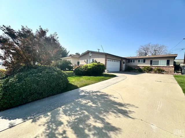 a view of house with yard and car parked