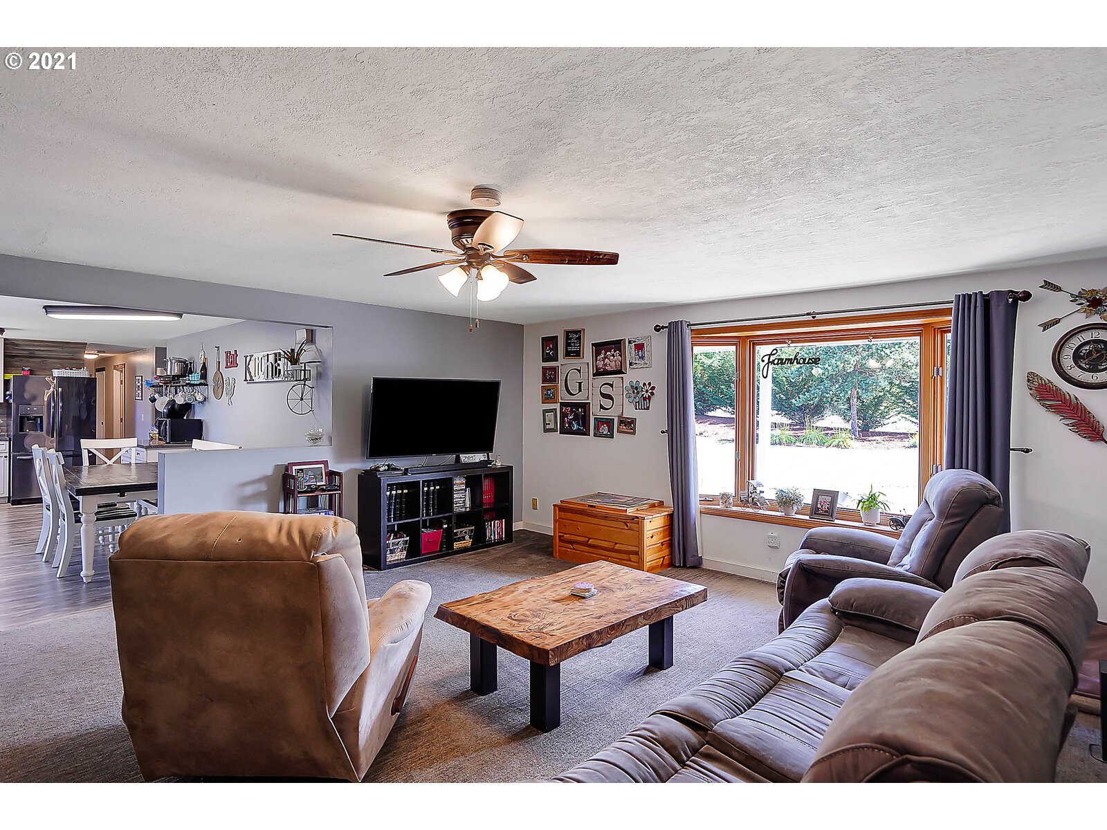15145 Guthrie Road Dallas, OR 97338 - Photo 6 of 32 a living room with furniture a flat screen tv and a large window