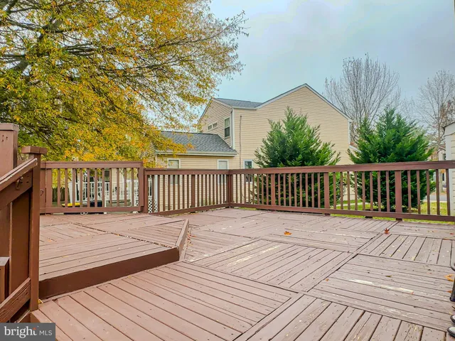a view of deck with wooden floor and fence with a bench