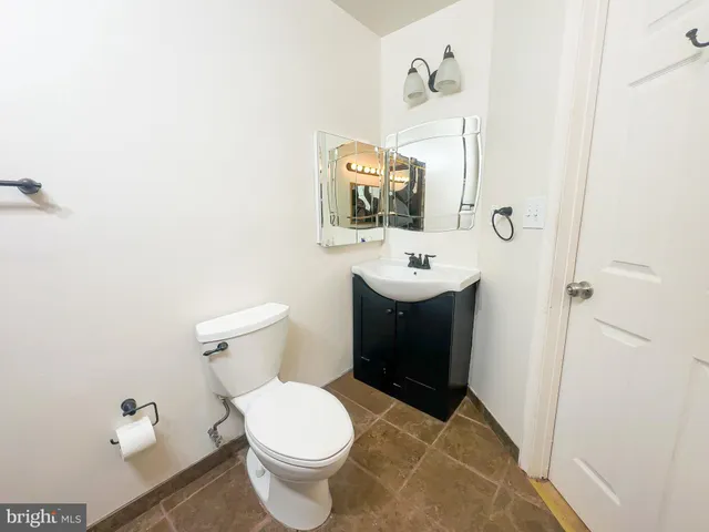 a bathroom with a toilet a sink and mirror