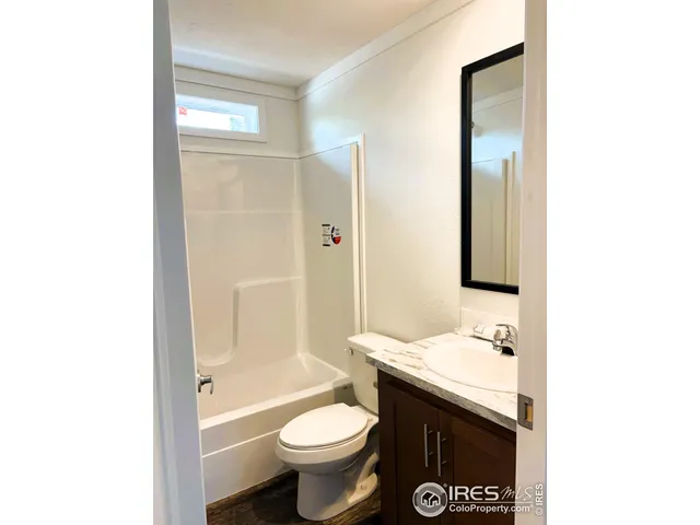 a bathroom with a granite countertop toilet a sink and a bathtub