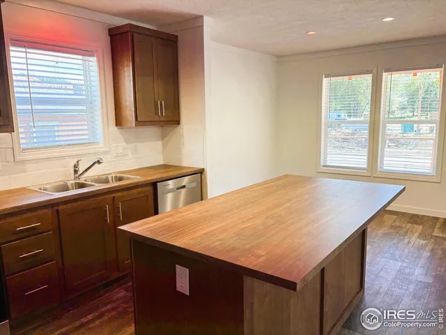 a kitchen with a sink a window and cabinets