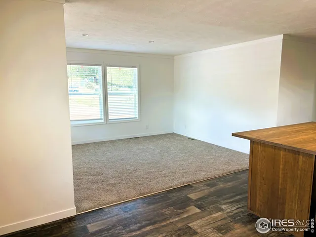 an empty room with wooden floor and a window