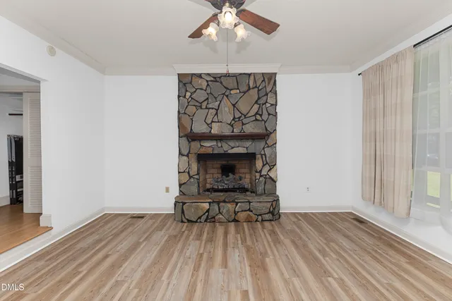 a view of a livingroom with wooden floor and a fireplace
